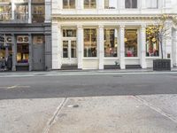 street corner with a building and stores on either side of the road where it stands