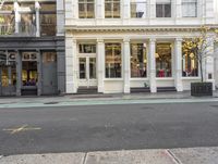 street corner with a building and stores on either side of the road where it stands