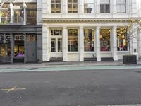 street corner with a building and stores on either side of the road where it stands