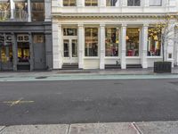 street corner with a building and stores on either side of the road where it stands