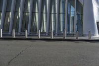 the man is on his skateboard in front of the building's glass exterior