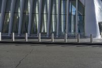 the man is on his skateboard in front of the building's glass exterior