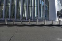 the man is on his skateboard in front of the building's glass exterior