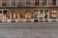 a store with a clock on it in a street next to building and cars behind it