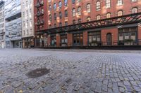 an empty cobble stone street surrounded by tall buildings in the city of boston, usa