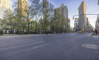 empty city street with no traffic in the background and tree - lined buildings, intersection