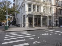 an intersection of a city street with a pedestrian walking by the street and a building