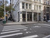 an intersection of a city street with a pedestrian walking by the street and a building