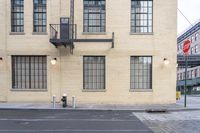 the view from a sidewalk of the fire escape staircase and some windows in a large building