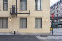 the view from a sidewalk of the fire escape staircase and some windows in a large building