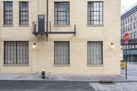 the view from a sidewalk of the fire escape staircase and some windows in a large building