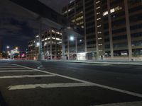 a blurry photo of a city street at night with tall buildings and lights in the background