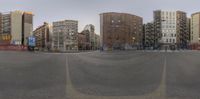 a street that has been blocked off by a bunch of buildings in the background and with a pole on each side