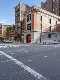 a view down the road of a building that is a corner with a large red door