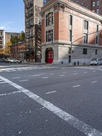 a view down the road of a building that is a corner with a large red door