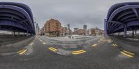 two panoramic images one shows an empty road with the other shows the street and a tall building in the background