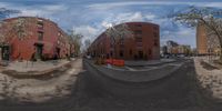 some 360 - pane image of the street in front of an apartment complex and a blue sky