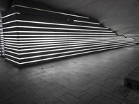 an image of a long wall lit up with neons in black and white,