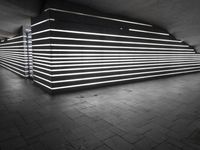 an image of a long wall lit up with neons in black and white,