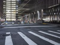 a stop sign sitting in the middle of an empty street near tall buildings and a road with lines