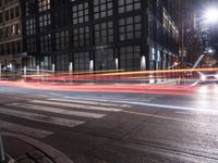 the city street has long exposures and motion bluring it through it, with traffic on either side of it