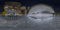 a fish shaped object is on the sidewalk next to tall buildings at night in the city