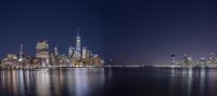 a view of the city and skyline at night from a pier overlooking a water - front