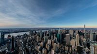 an aerial view of the city skyline of new york harbor and manhattan bridge in a clear blue sky