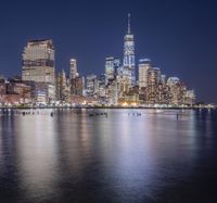 a night shot of the city and its reflection in the water of the ocean front