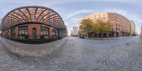 multiple fish - eye lens images show different buildings and spaces in an urban setting with cobblestone