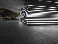 the large empty parking garage is lit up with white lights and grey brick floors and walls