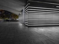 the large empty parking garage is lit up with white lights and grey brick floors and walls