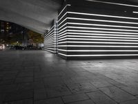 the large empty parking garage is lit up with white lights and grey brick floors and walls