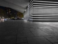 the large empty parking garage is lit up with white lights and grey brick floors and walls