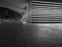 the large empty parking garage is lit up with white lights and grey brick floors and walls