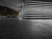 the large empty parking garage is lit up with white lights and grey brick floors and walls