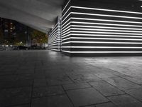 the large empty parking garage is lit up with white lights and grey brick floors and walls