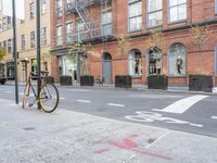 a bicycle is parked on the side of the street in front of a large brick building