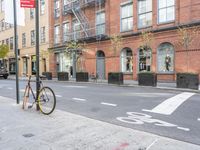 a bicycle is parked on the side of the street in front of a large brick building