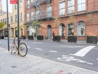 a bicycle is parked on the side of the street in front of a large brick building