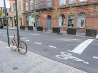 a bicycle is parked on the side of the street in front of a large brick building