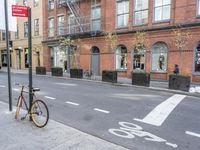 a bicycle is parked on the side of the street in front of a large brick building