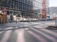 a manhole sitting in the middle of an urban street near a building that is being built