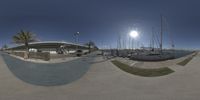 a fish eye lens of some sail boats docked in a marina and an empty lot