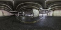 a large circular parking garage with a car parked inside of it and people in the parking garage looking at it