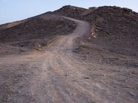 a truck on a dirt road in the desert with rocks and stones on the ground