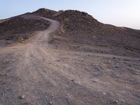 a truck on a dirt road in the desert with rocks and stones on the ground