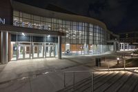 a night scene with a lit up entrance to the main school building on the college campus