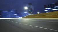 a blurred photograph of a street with buildings at night in the background for use as a wallpaper