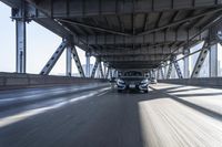 the new mercedes benz c - class driving under a bridge and above it is another car